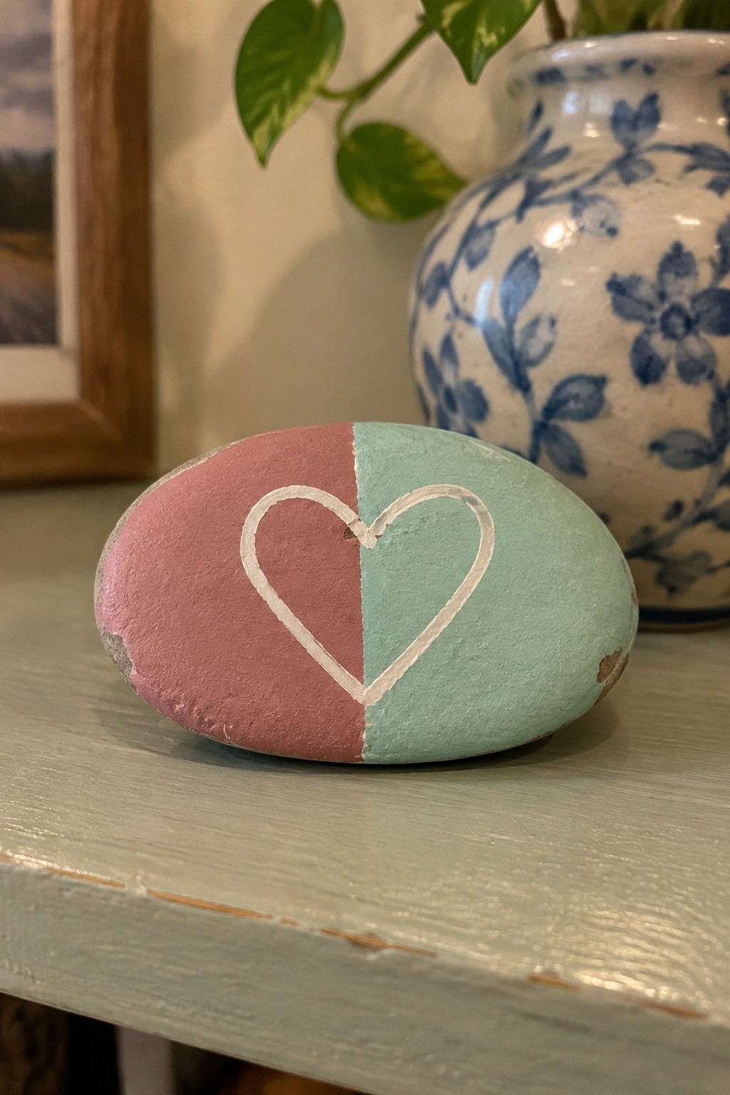 Painted oval rock split pink and mint green with white heart outline
